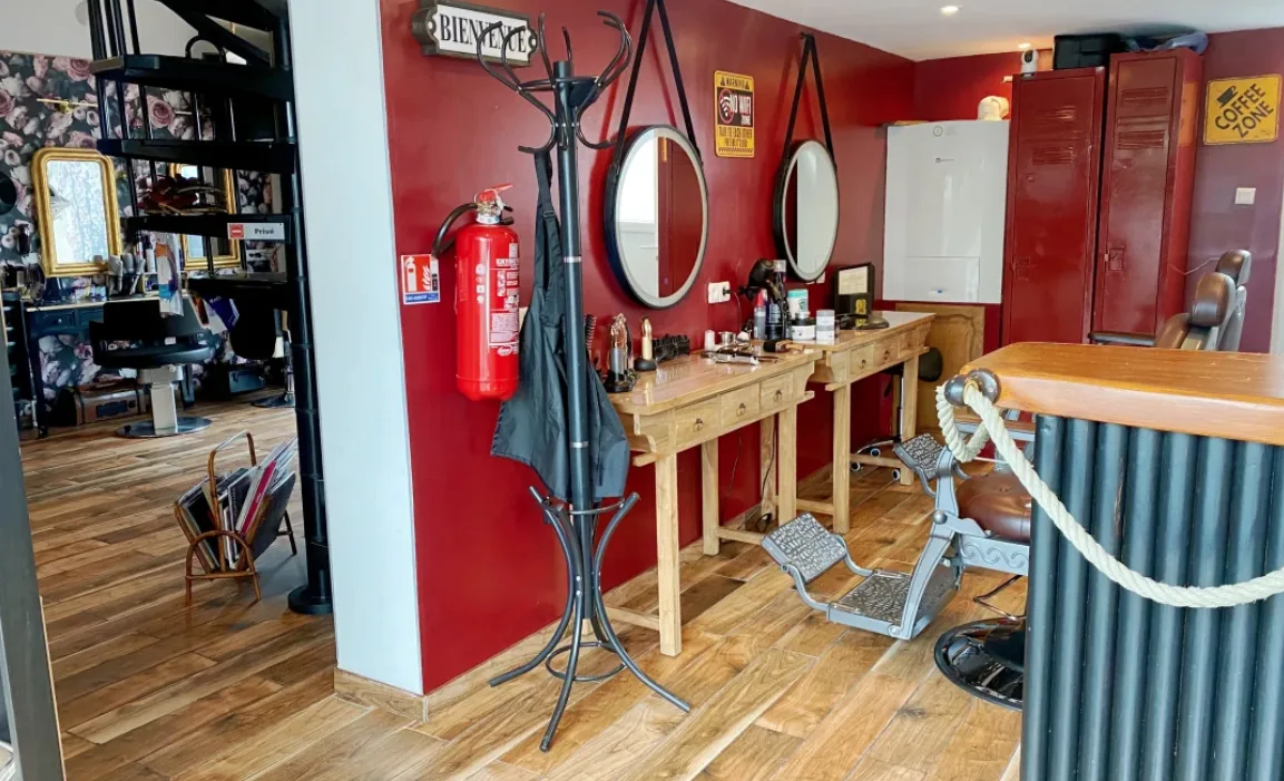 Espace barbier au mur bordeaux et miroirs ronds — coiffeur homme à Calais