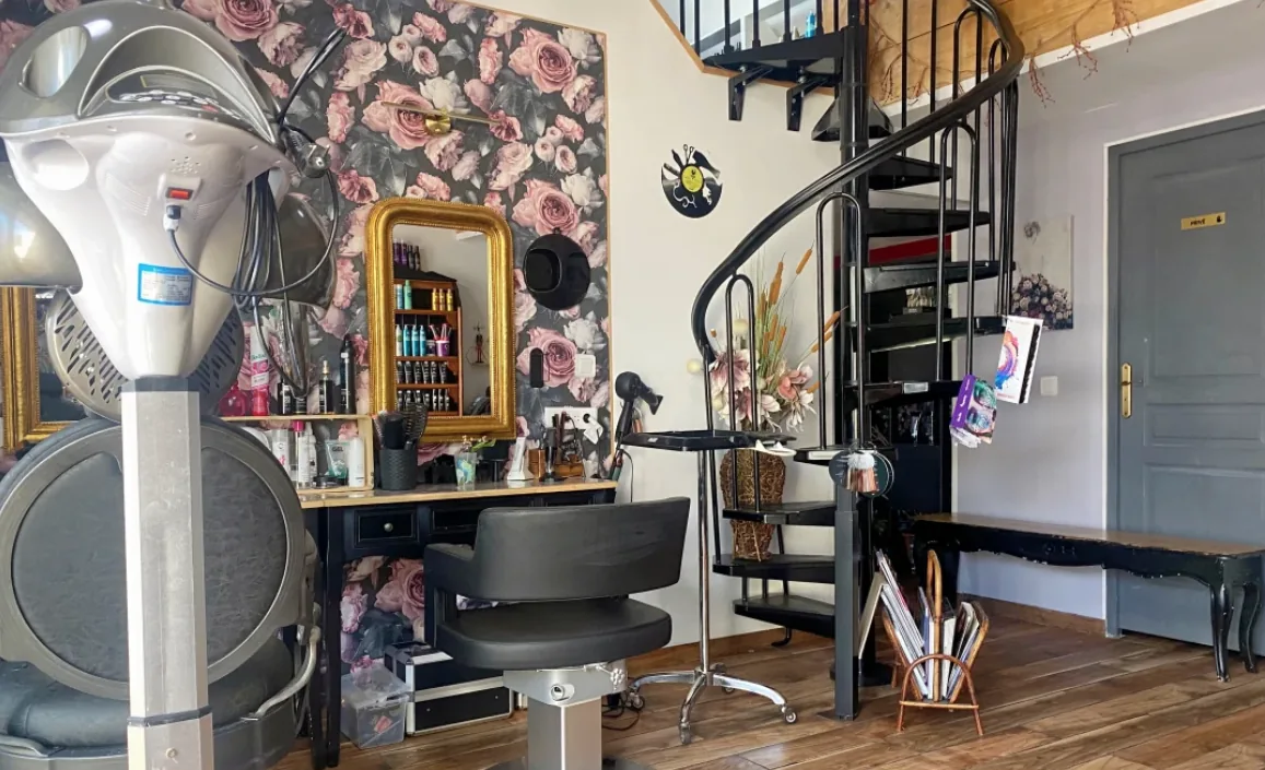 Espace coiffage au papier peint floral et miroir doré — Le Salon d'Or, salon de coiffure à Calais