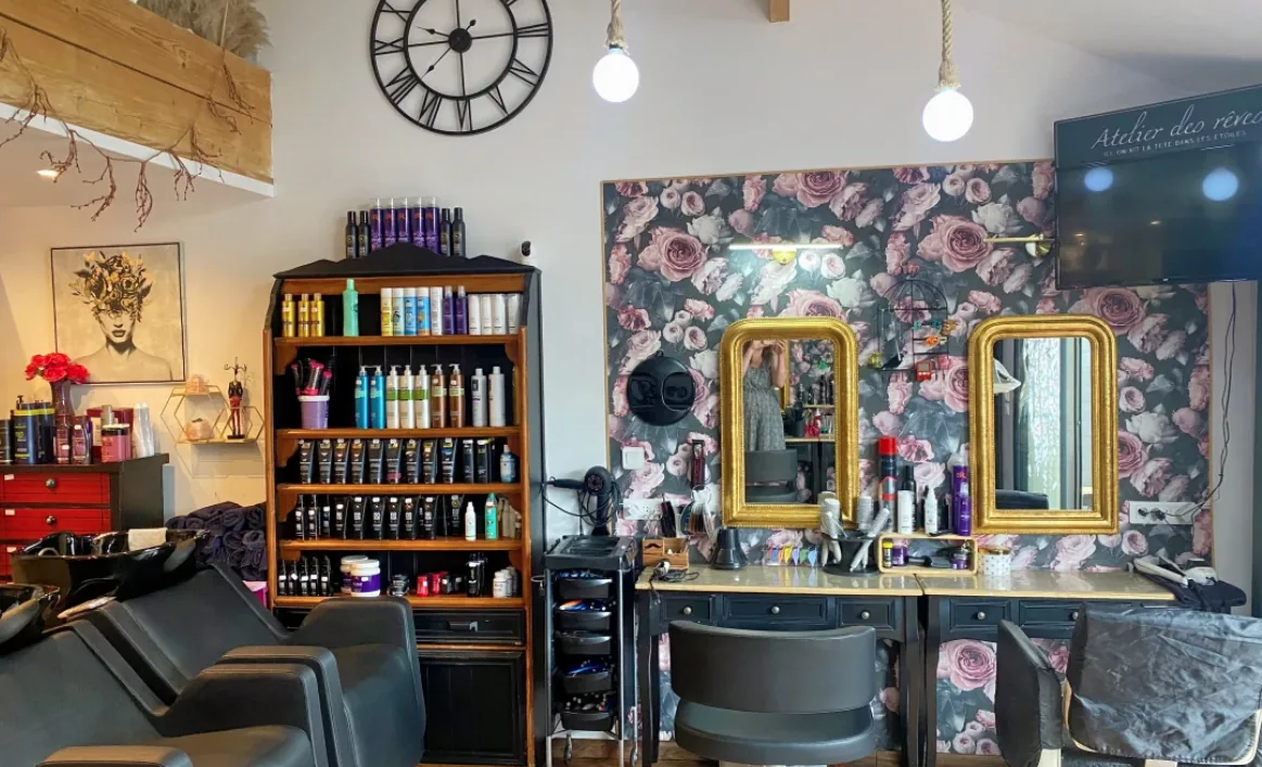 Coiffeuses avec miroirs dorés baroques et papier peint floral — salon de coiffure à Calais